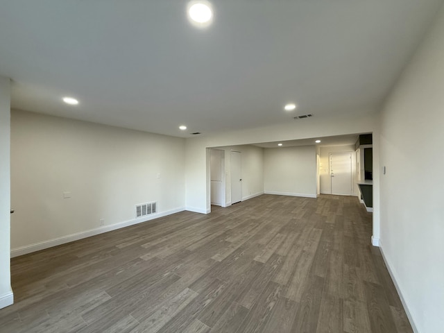 interior space featuring dark wood-style flooring, visible vents, and baseboards