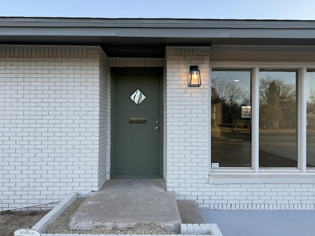 entrance to property featuring brick siding