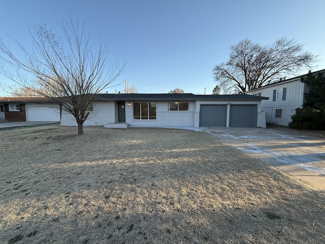 view of front facade featuring a garage, concrete driveway, and brick siding