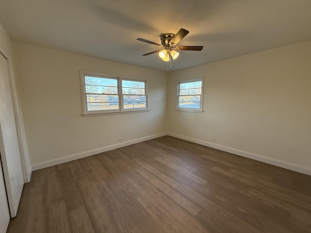 unfurnished bedroom featuring dark wood finished floors, baseboards, and ceiling fan