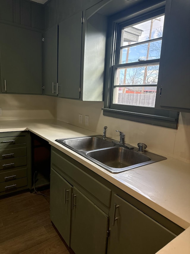kitchen featuring a sink, dark wood-style flooring, and light countertops
