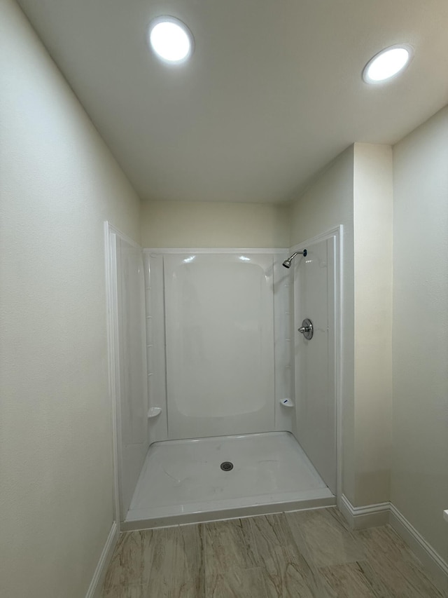 full bath with a shower and baseboards