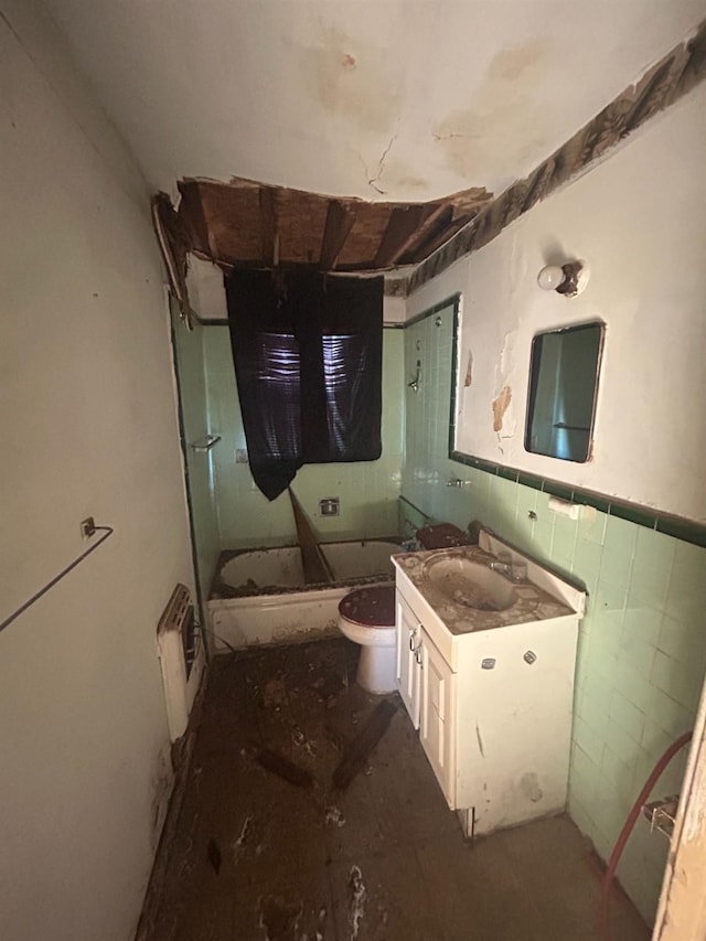 bathroom with walk in shower, vanity, toilet, and tile walls