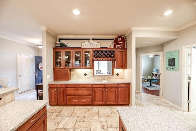 kitchen featuring ornamental molding, backsplash, and light stone counters