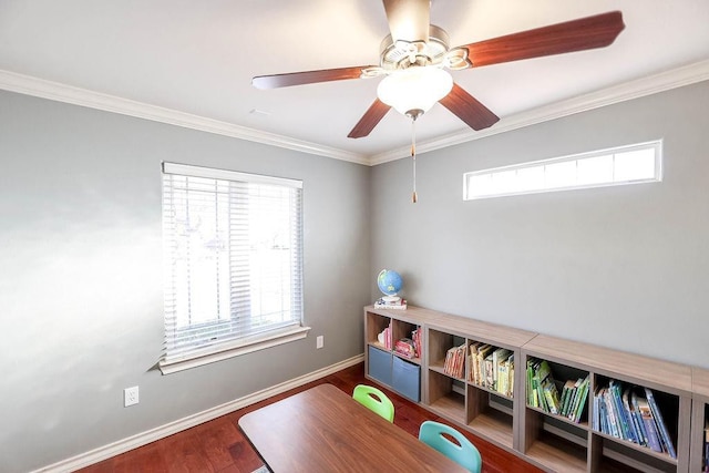 playroom with crown molding, dark wood-type flooring, and ceiling fan