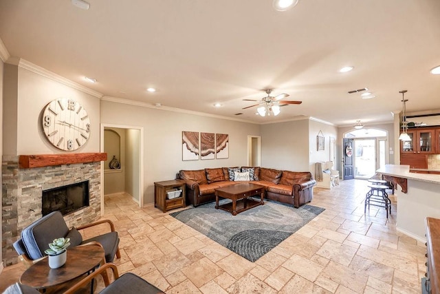 living room featuring crown molding, a fireplace, and ceiling fan