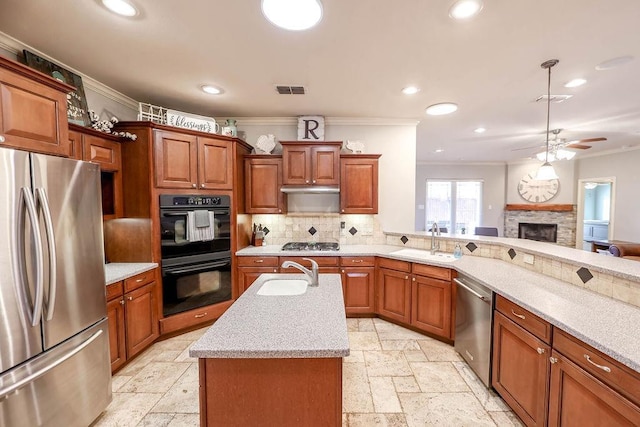 kitchen with sink, crown molding, an island with sink, and appliances with stainless steel finishes