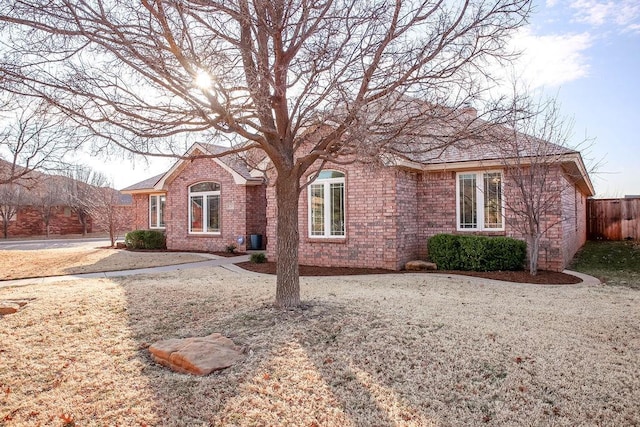 ranch-style house featuring brick siding and fence