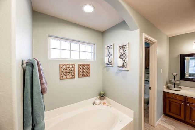 bathroom with vanity, toilet, tile patterned flooring, and a bath