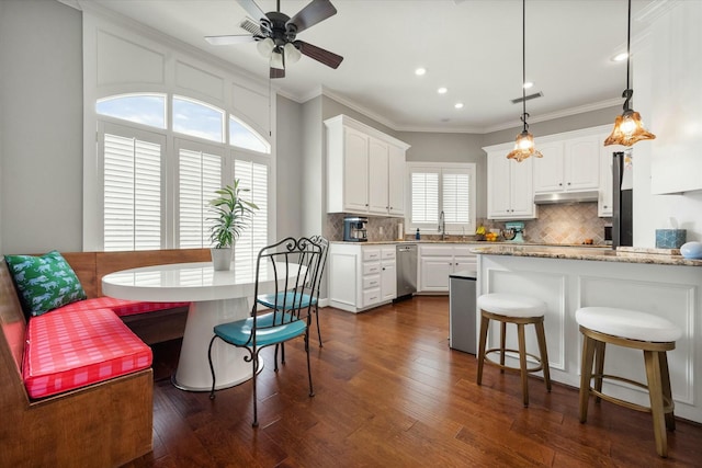 9214 York Pl, Lubbock, TX 79424 - kitchen with white cabinetry, recessed lighting, decorative backsplash, under cabinet range hood, and ornamental molding