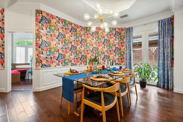 9214 York Pl, Lubbock, TX 79424 - dining space with visible vents, crown molding, dark wood-style flooring, a wainscoted wall, and a chandelier
