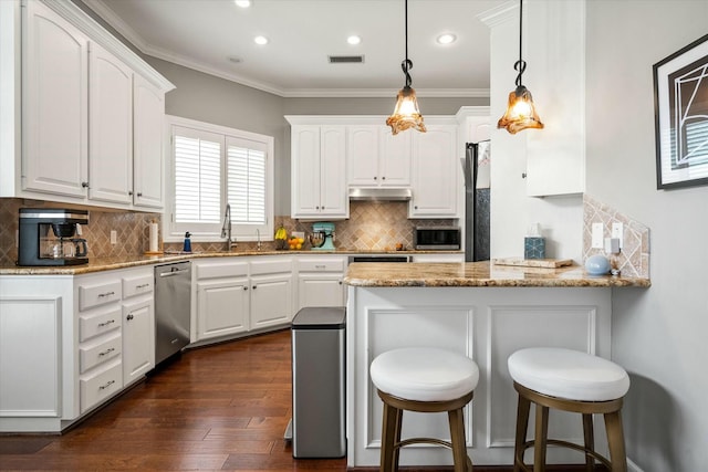 9214 York Pl, Lubbock, TX 79424 - kitchen with a sink, stainless steel appliances, a peninsula, under cabinet range hood, and visible vents