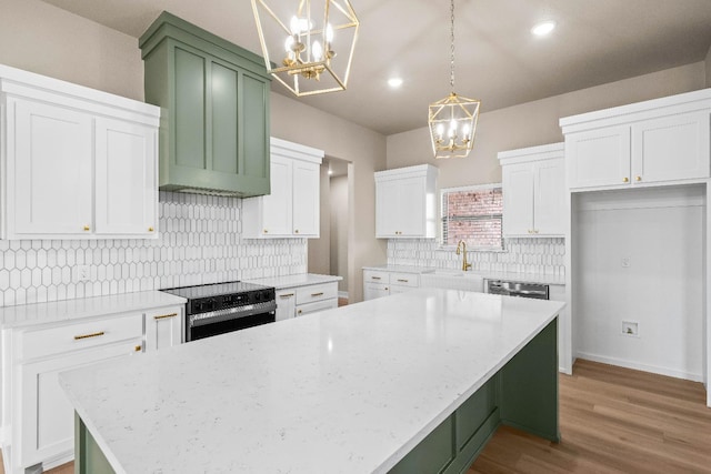 kitchen featuring a kitchen island, pendant lighting, white cabinetry, electric range, and light stone counters