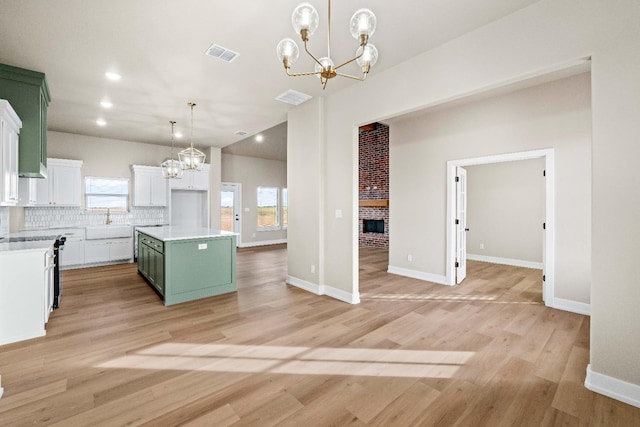 kitchen featuring an inviting chandelier, decorative backsplash, decorative light fixtures, and a kitchen island