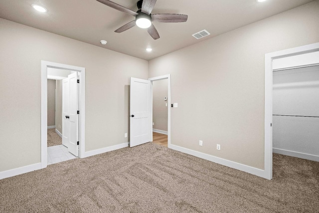 unfurnished bedroom featuring light colored carpet, connected bathroom, a closet, and a walk in closet