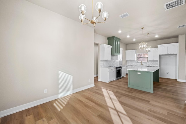 kitchen featuring a notable chandelier, stainless steel stove, green cabinetry, and a kitchen island