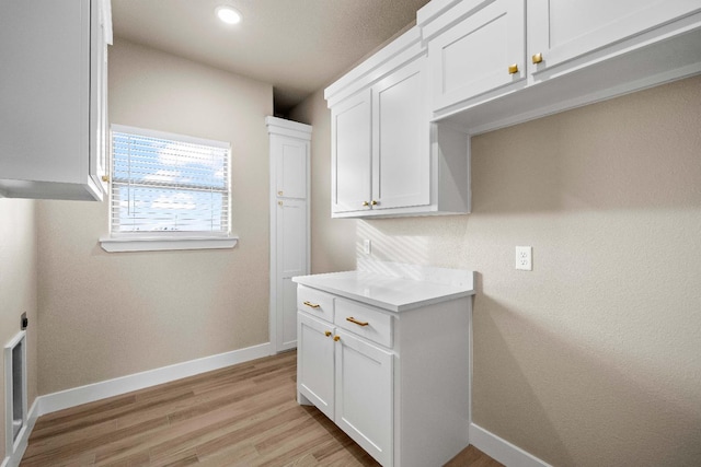 clothes washing area with light hardwood / wood-style flooring