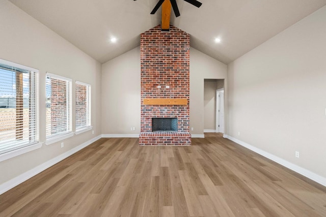 unfurnished living room with beamed ceiling, a fireplace, high vaulted ceiling, and light hardwood / wood-style flooring