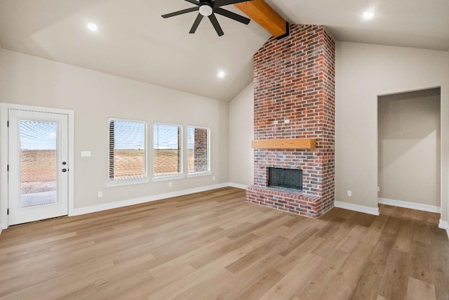 unfurnished living room with beamed ceiling, high vaulted ceiling, a fireplace, and light hardwood / wood-style floors