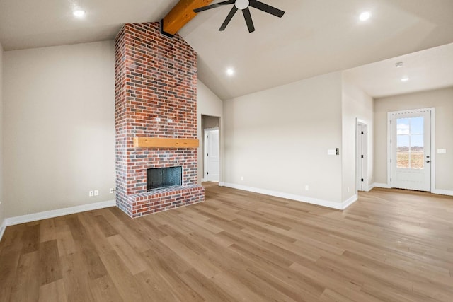 unfurnished living room with high vaulted ceiling, a brick fireplace, light hardwood / wood-style flooring, beamed ceiling, and ceiling fan