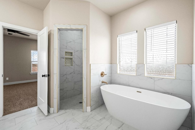 bathroom with separate shower and tub, a wealth of natural light, and tile walls