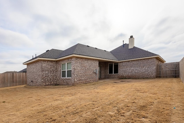 rear view of property with a yard