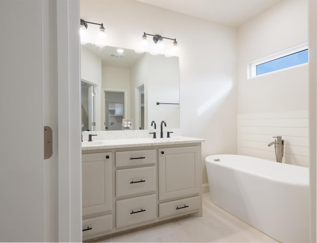 bathroom featuring vanity, a bathtub, and tile patterned floors