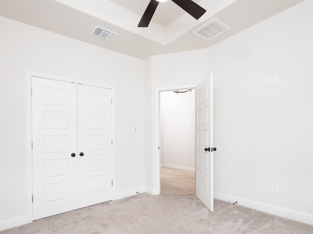 unfurnished bedroom featuring light colored carpet, a closet, and ceiling fan