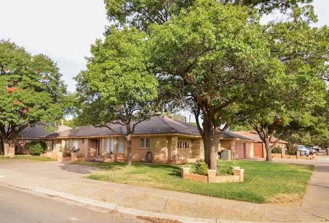 single story home with cooling unit and a front yard