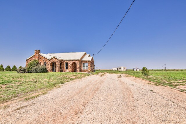 view of front of property with a rural view and a front yard