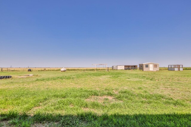 view of yard with a rural view and an outbuilding