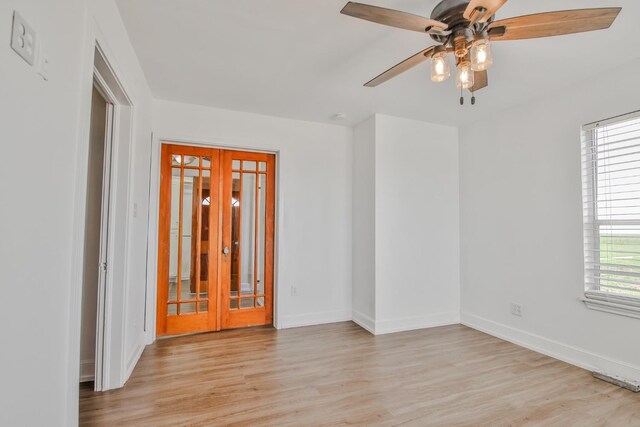 empty room featuring light hardwood / wood-style floors, french doors, and ceiling fan