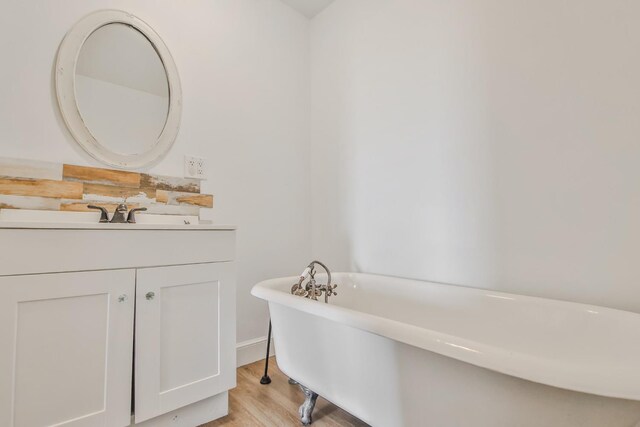 bathroom featuring vanity, a bath, and hardwood / wood-style floors