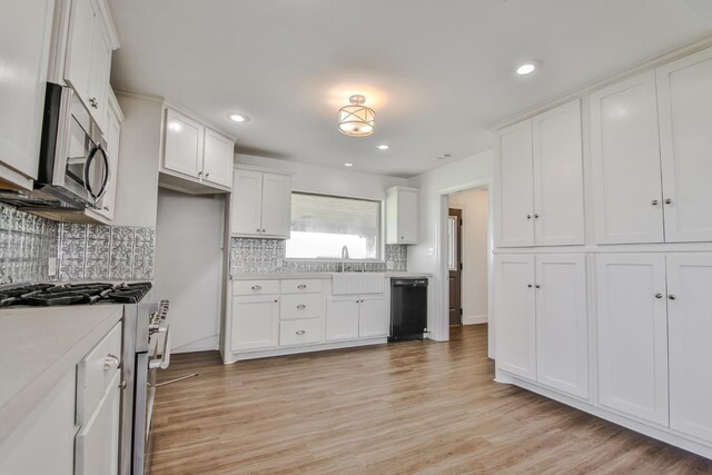 kitchen with light hardwood / wood-style floors, white cabinets, and appliances with stainless steel finishes