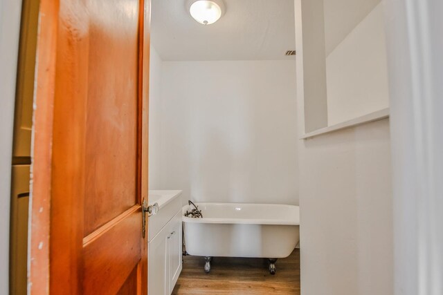 bathroom with a tub and hardwood / wood-style floors