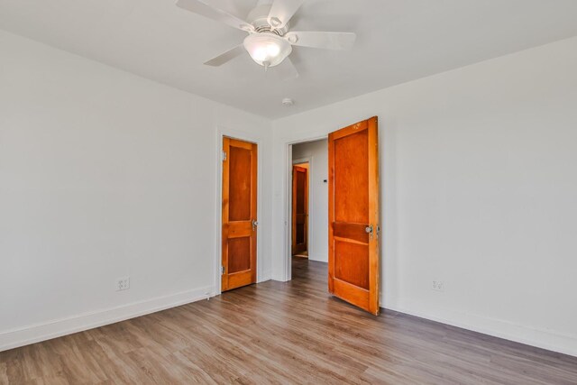 empty room with ceiling fan and light hardwood / wood-style floors