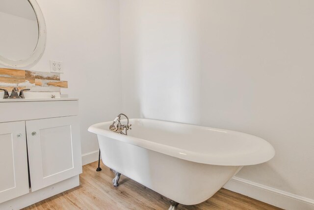 bathroom featuring a tub to relax in, hardwood / wood-style floors, and vanity