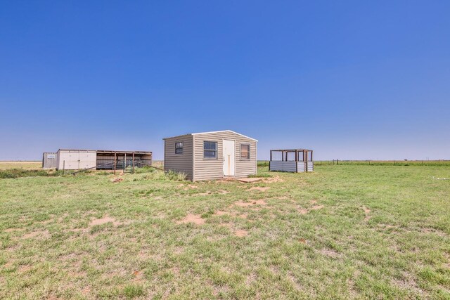 view of yard featuring a rural view and a storage unit