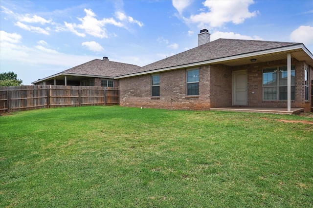 back of house featuring a patio area and a lawn