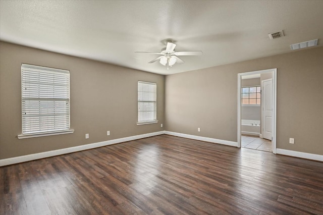 empty room featuring ceiling fan and dark hardwood / wood-style floors