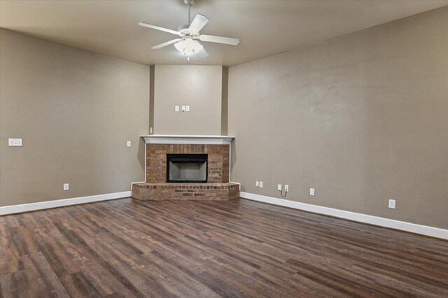 unfurnished living room with dark wood-type flooring, a fireplace, and ceiling fan