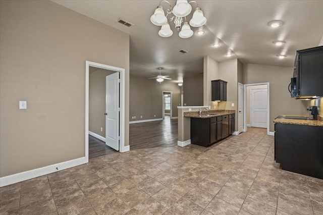 kitchen featuring lofted ceiling, sink, light stone countertops, ceiling fan with notable chandelier, and tile patterned floors