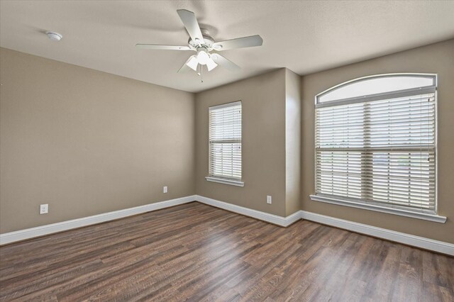 empty room featuring ceiling fan and dark hardwood / wood-style flooring