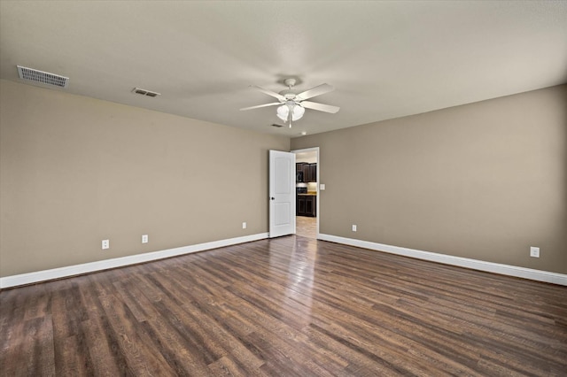 spare room with dark wood-type flooring and ceiling fan