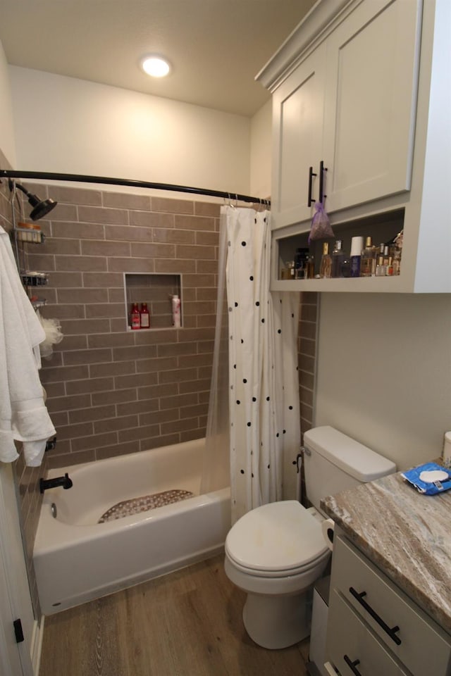 bathroom with toilet, shower / tub combo with curtain, wood finished floors, and vanity