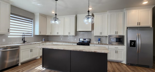 kitchen featuring stainless steel appliances, dark wood-style flooring, a kitchen island, a sink, and white cabinets