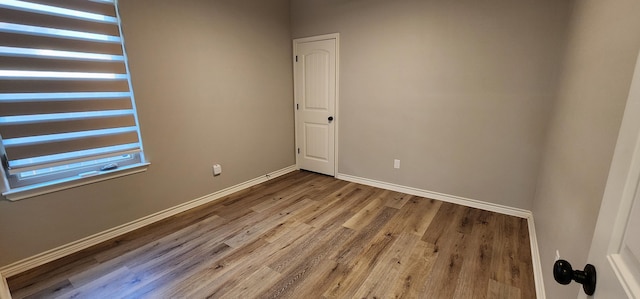 empty room with baseboards and wood finished floors