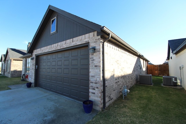 garage with fence and central AC unit