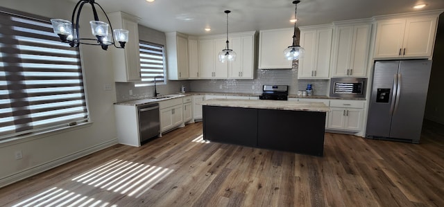 kitchen with tasteful backsplash, appliances with stainless steel finishes, white cabinets, and dark wood-style flooring