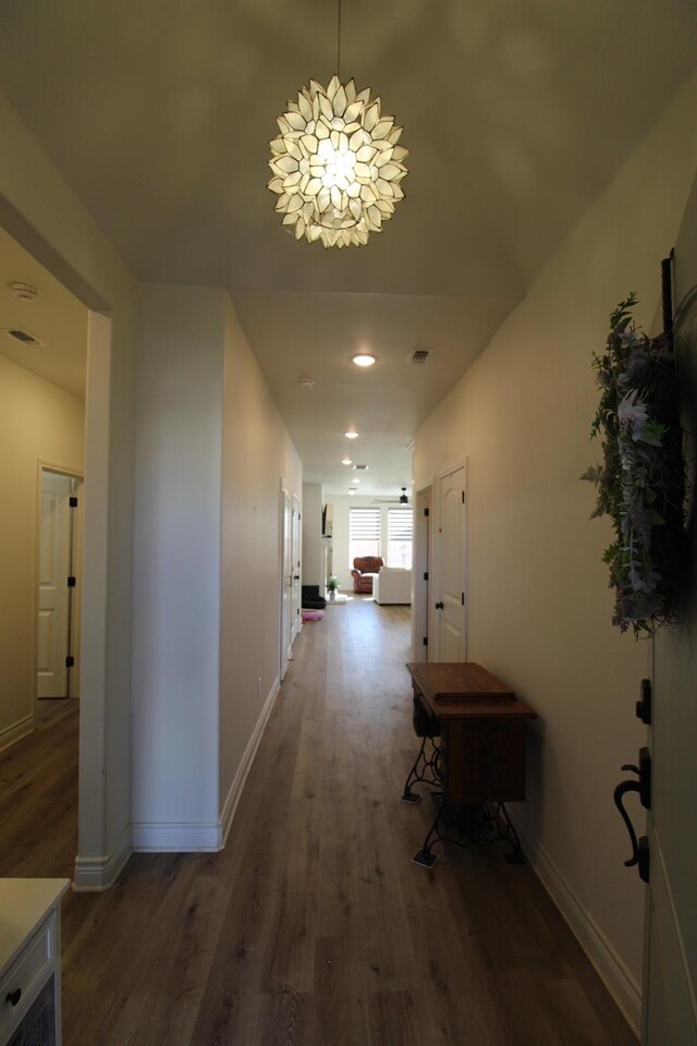 hall with dark wood-style floors and baseboards